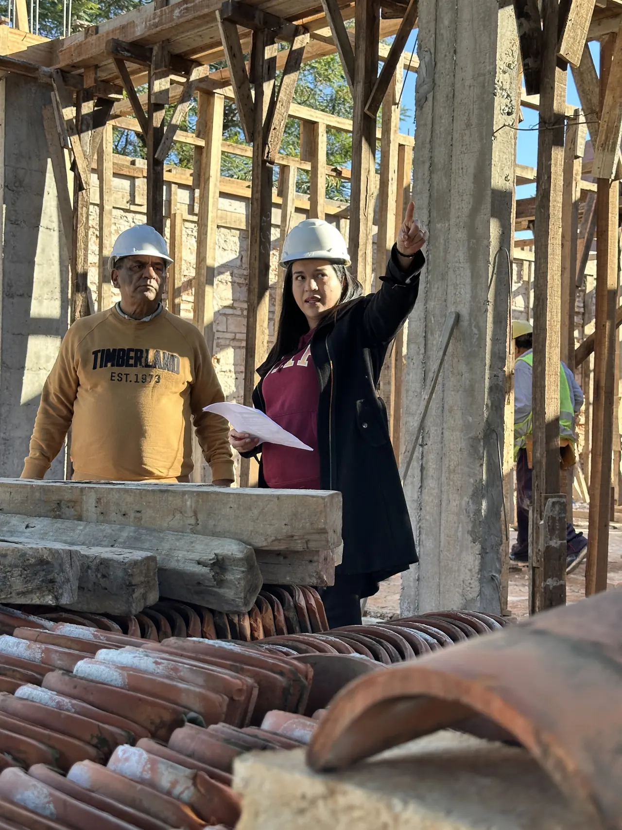 Analía coordinando detalles con el equipo en una obra