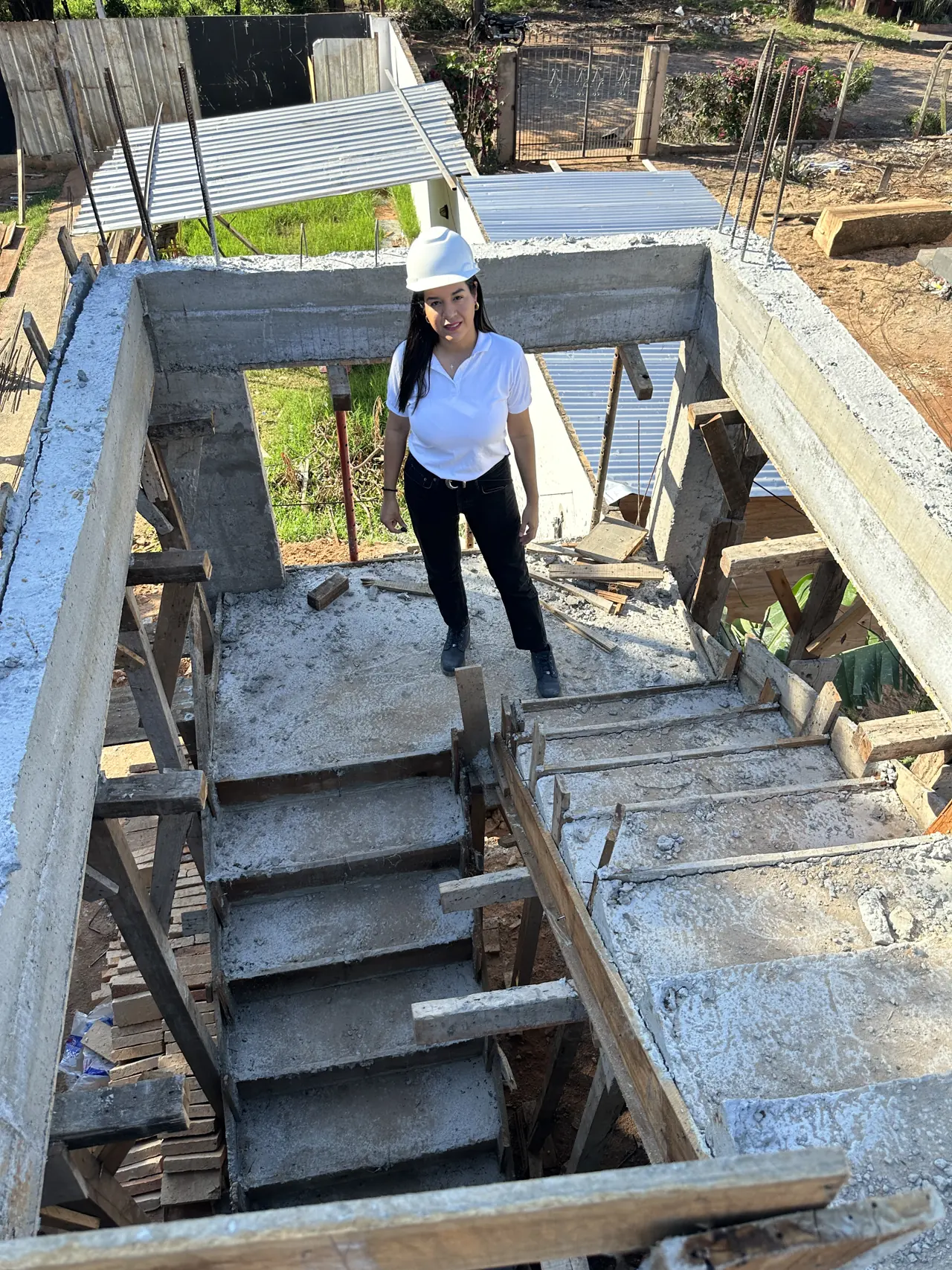 Analía en la escalera de hormigón de una vivienda en construcción