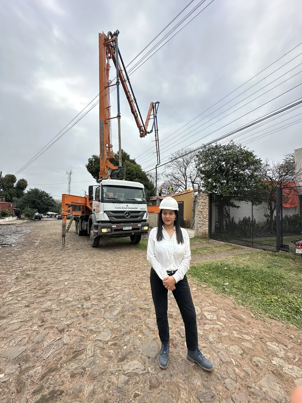 Analía junto al camión de bombeo de hormigón frente a la obra